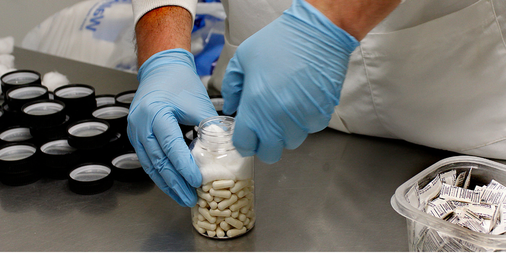 Vireo technician filling bottle of capsules